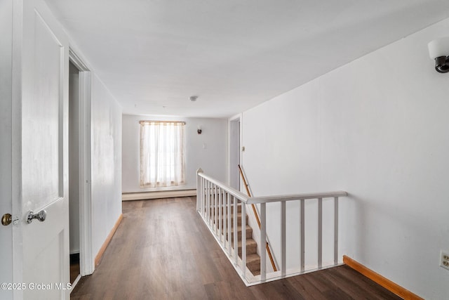 hallway with a baseboard radiator, wood finished floors, and an upstairs landing