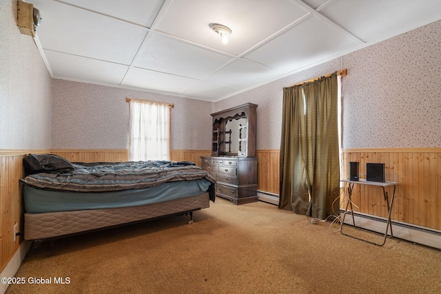 carpeted bedroom with a baseboard heating unit, wood walls, wainscoting, and wallpapered walls