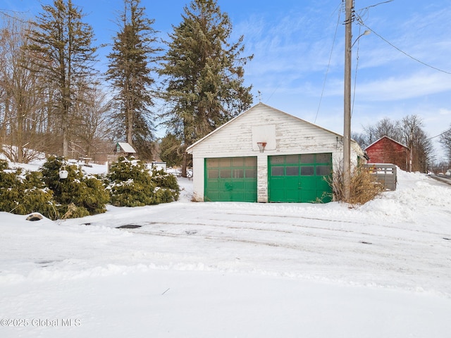 snow covered garage with a detached garage