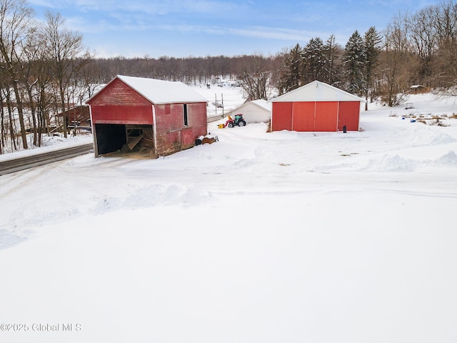 snow covered structure featuring an outbuilding and a pole building