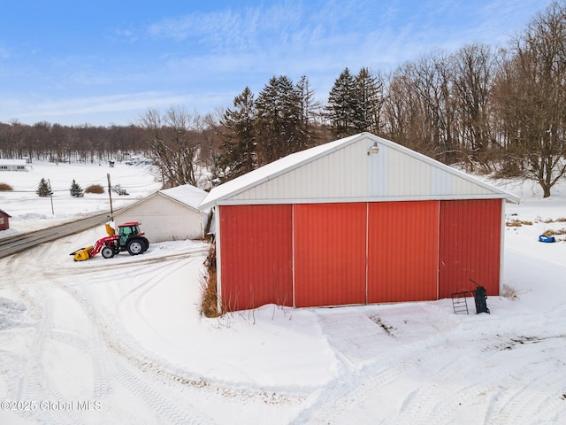 snow covered structure featuring an outbuilding