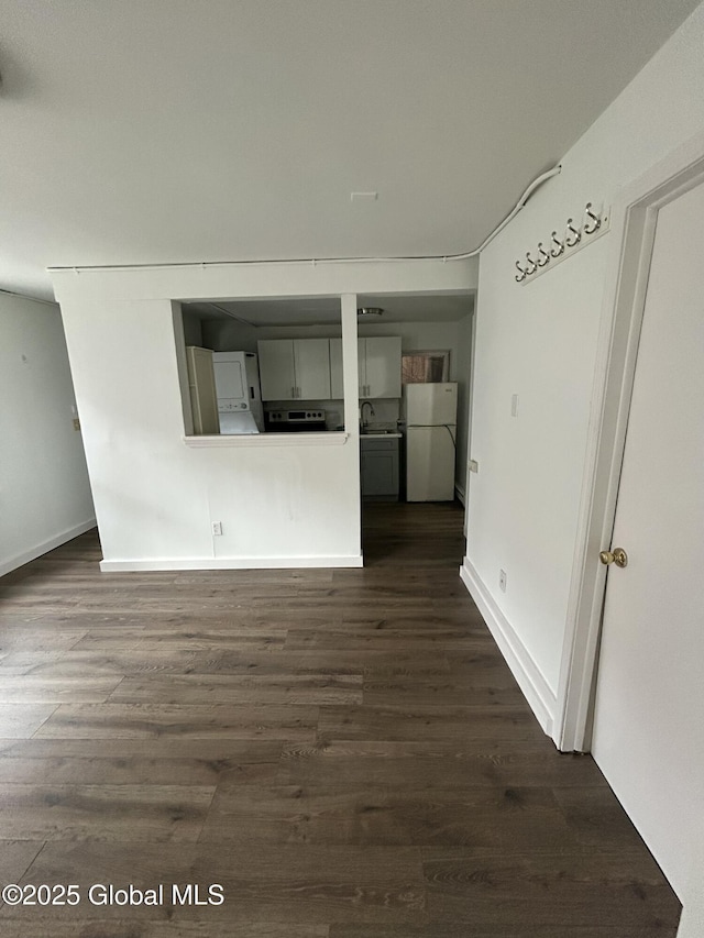 unfurnished living room with dark wood-style flooring and baseboards