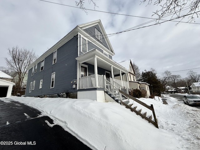 view of snow covered exterior featuring covered porch