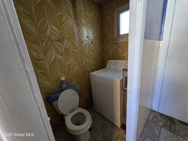 bathroom featuring washer / dryer and toilet