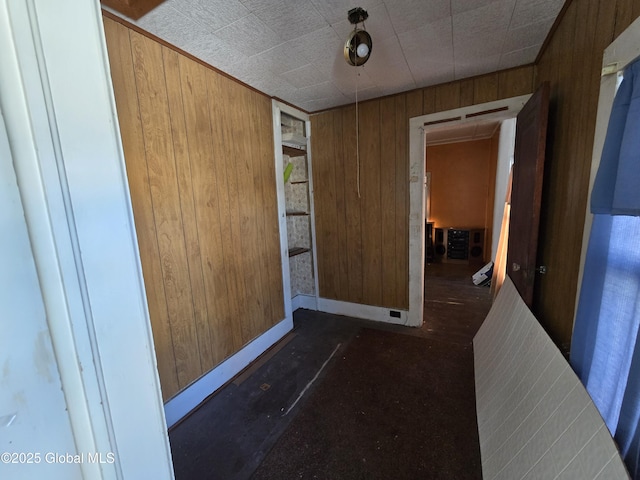 hallway featuring wooden walls