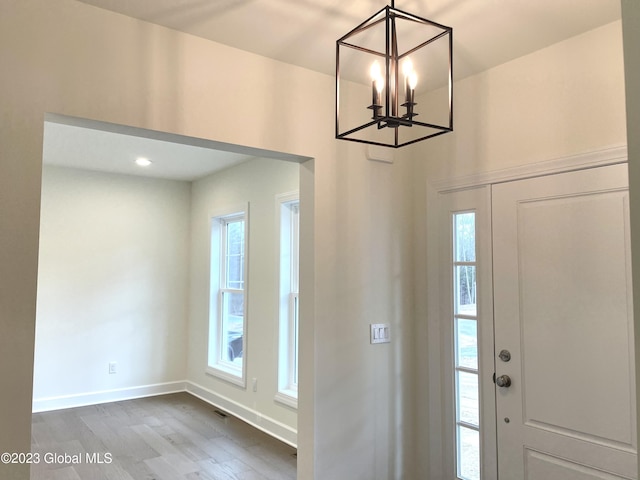 entryway featuring hardwood / wood-style floors and an inviting chandelier