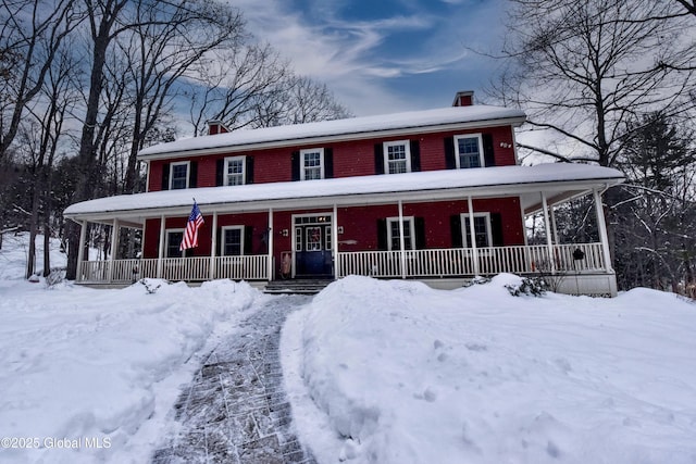 view of front facade with covered porch and a chimney