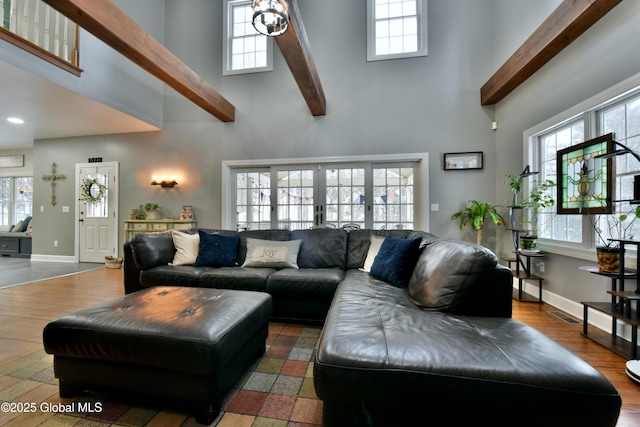 living area with a wealth of natural light, beam ceiling, and a towering ceiling