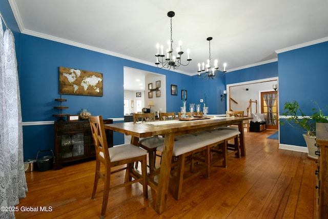 dining area featuring a chandelier, hardwood / wood-style floors, and crown molding