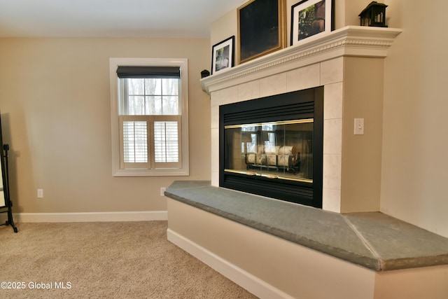 interior details featuring carpet, a tiled fireplace, and baseboards