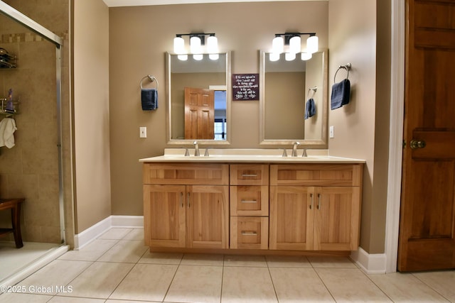 full bathroom with tile patterned floors, a sink, a shower stall, and double vanity