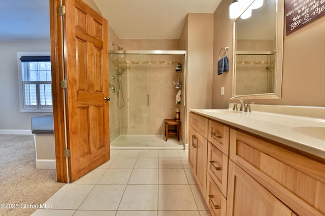 bathroom with tile patterned flooring, a sink, a shower stall, and double vanity