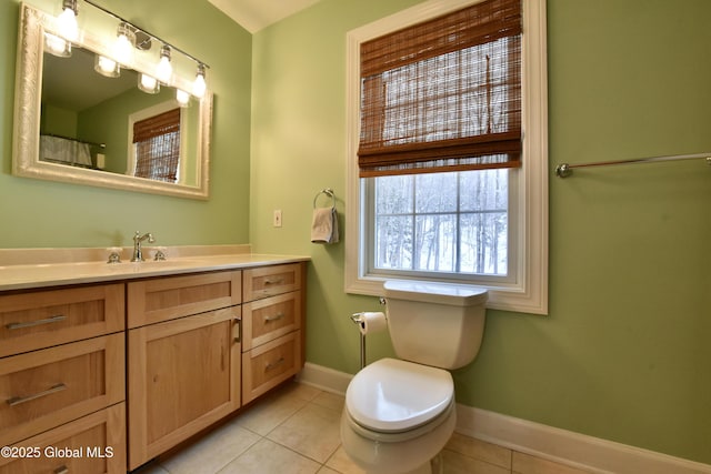 bathroom with tile patterned flooring, baseboards, vanity, and toilet