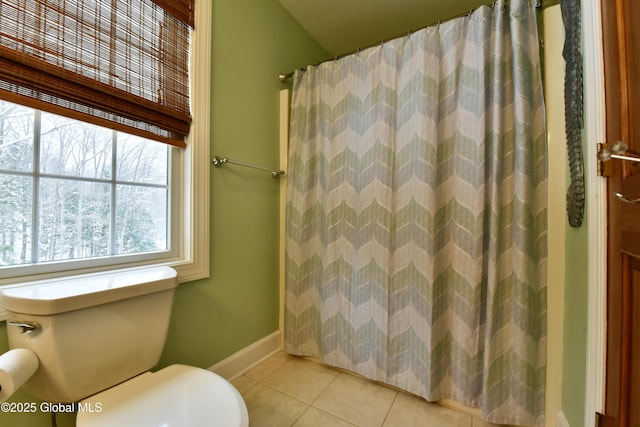 full bathroom featuring toilet, curtained shower, baseboards, and tile patterned floors