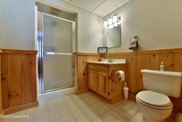 full bath featuring a stall shower, wainscoting, toilet, and tile patterned floors