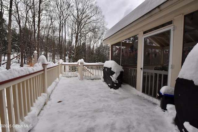 snow covered deck with a sunroom