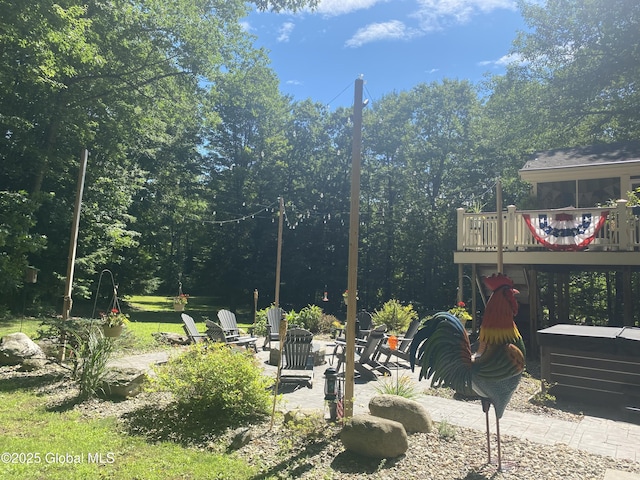 view of yard with a fire pit, a deck, and a patio area