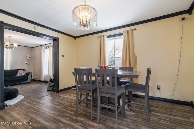 dining area with crown molding, dark hardwood / wood-style flooring, and a notable chandelier