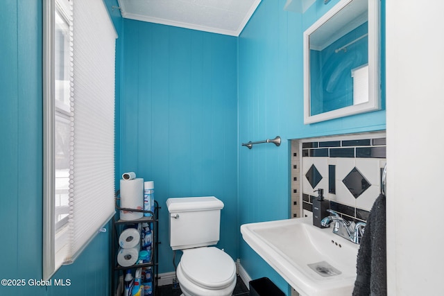 bathroom with ornamental molding, toilet, and sink