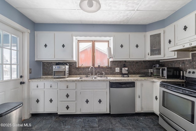 kitchen with sink, backsplash, white cabinets, and appliances with stainless steel finishes