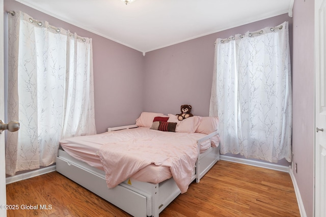 bedroom with crown molding and hardwood / wood-style flooring