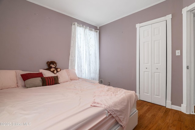 bedroom featuring crown molding, wood-type flooring, and a closet