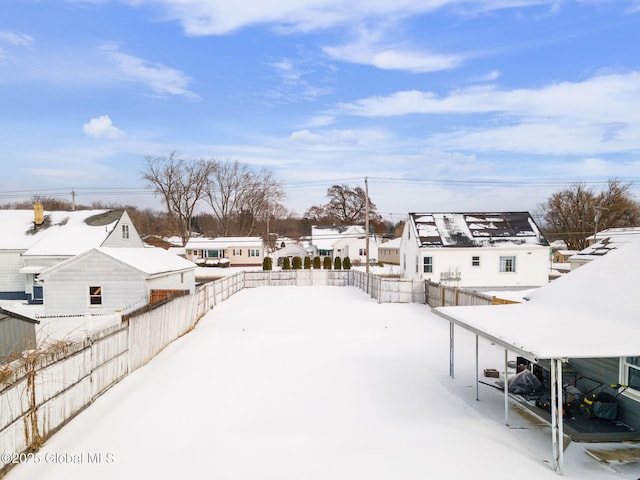 snowy yard featuring a carport