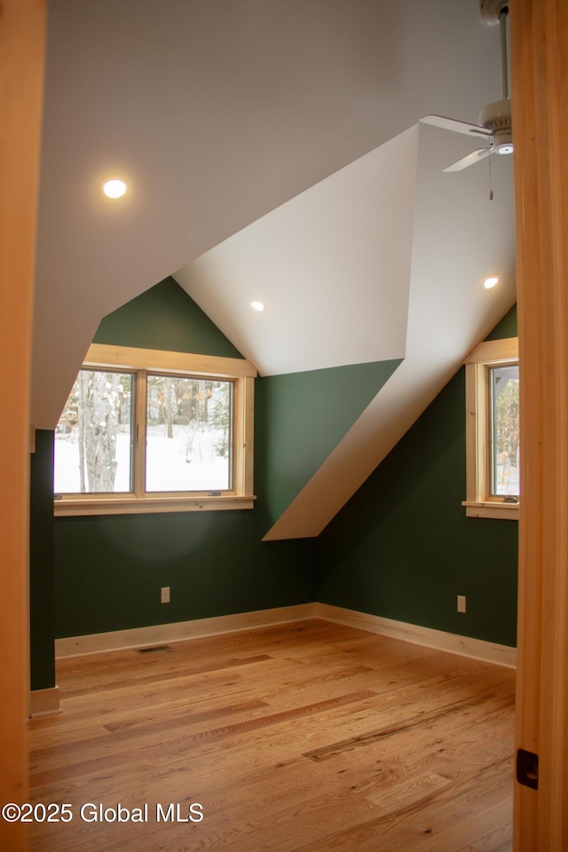 additional living space with light wood-type flooring and vaulted ceiling