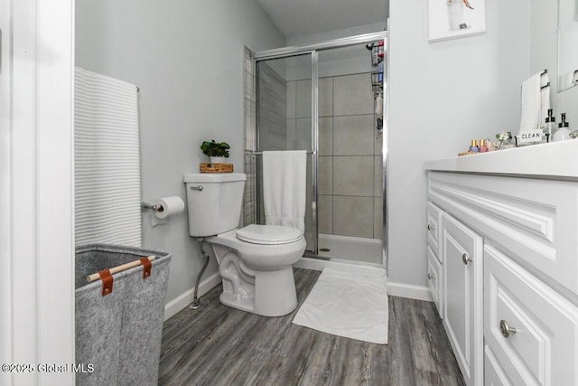 bathroom with toilet, a shower with door, and hardwood / wood-style floors