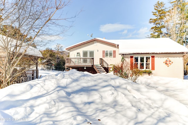 snow covered property with a wooden deck