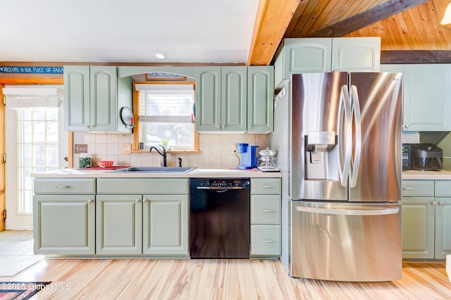 kitchen featuring stainless steel fridge, black dishwasher, sink, and decorative backsplash