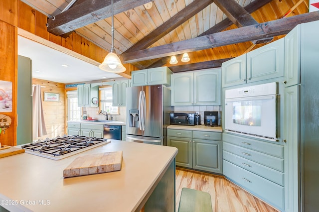 kitchen featuring vaulted ceiling with beams, pendant lighting, backsplash, and black appliances