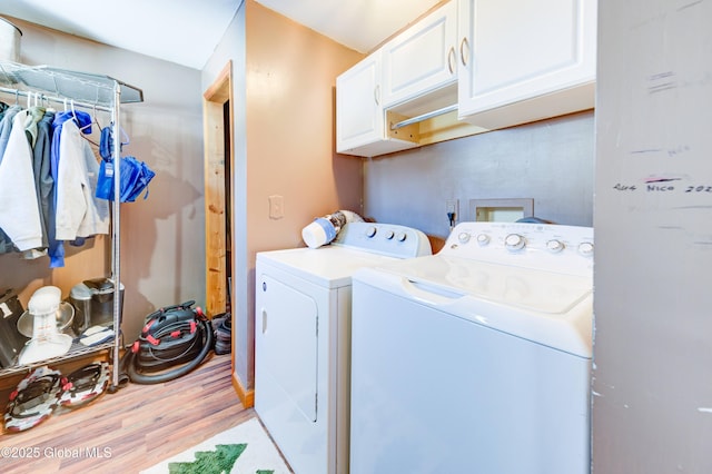 washroom with washer and dryer, light hardwood / wood-style floors, and cabinets