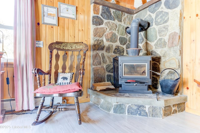 details featuring wood-type flooring, a wood stove, and wood walls