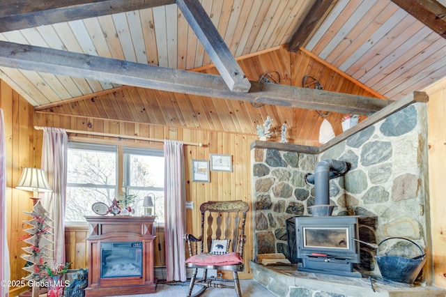 living room with vaulted ceiling with beams, wood ceiling, a wood stove, baseboard heating, and wooden walls