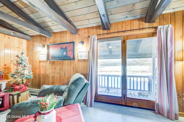 living area featuring baseboard heating, lofted ceiling with beams, light hardwood / wood-style floors, wooden ceiling, and wood walls