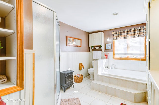 full bathroom featuring a wood stove, tile patterned flooring, vanity, separate shower and tub, and toilet