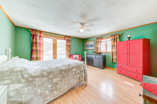 bedroom featuring ceiling fan, ornamental molding, a textured ceiling, access to outside, and light wood-type flooring