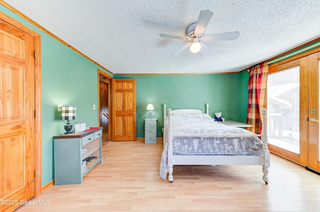 bedroom with crown molding, light wood-type flooring, a textured ceiling, and access to outside