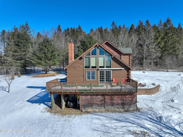 snow covered back of property featuring a wooden deck