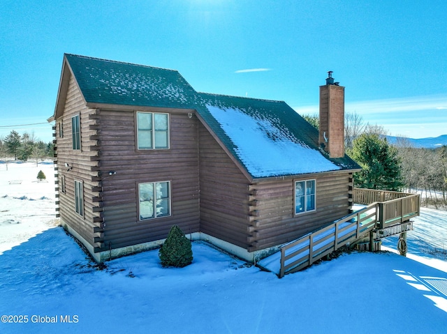 snow covered property with a deck