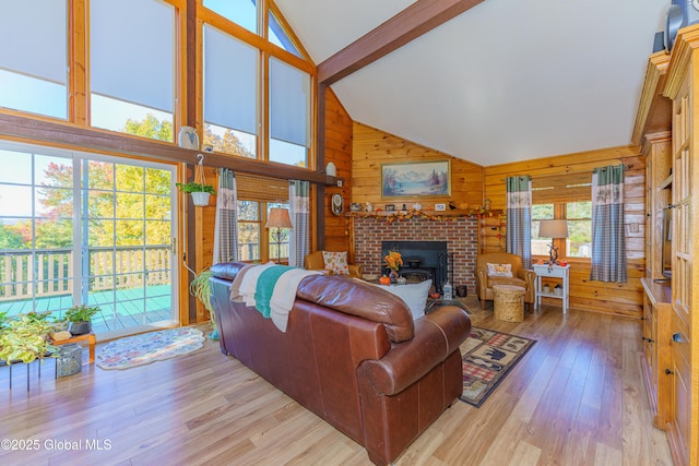 living room featuring high vaulted ceiling, light hardwood / wood-style floors, beamed ceiling, and wood walls