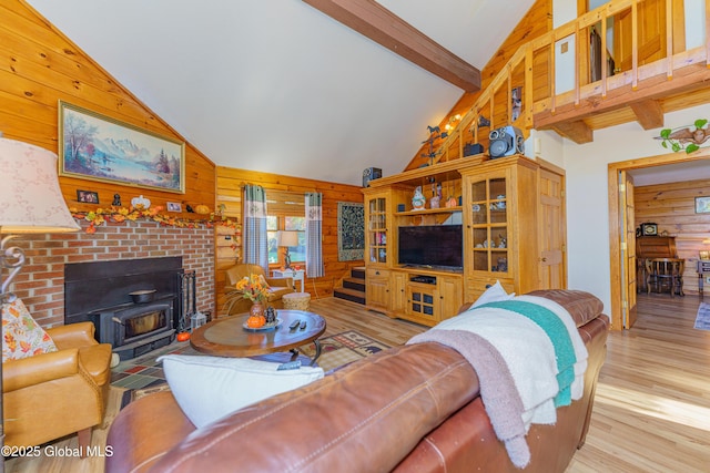 living room featuring light hardwood / wood-style flooring, wooden walls, high vaulted ceiling, and beamed ceiling