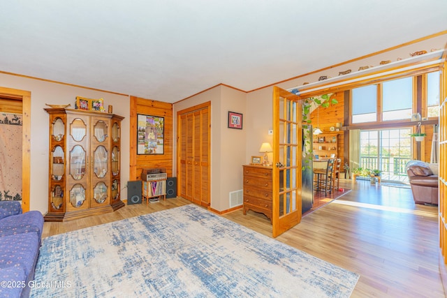 bedroom featuring wood-type flooring, ornamental molding, and a closet