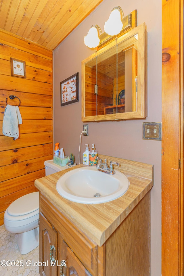 bathroom featuring wood ceiling, tile patterned flooring, vanity, toilet, and wood walls