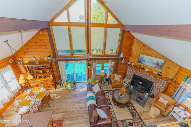 living room with wood-type flooring, high vaulted ceiling, and wooden walls