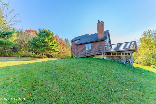 rear view of property featuring a wooden deck and a yard