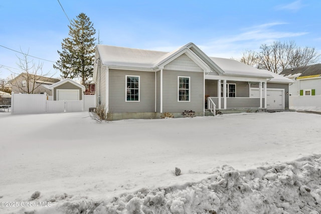 view of front of home featuring covered porch and a detached garage