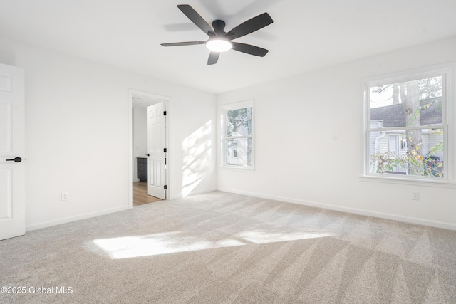 carpeted spare room featuring ceiling fan