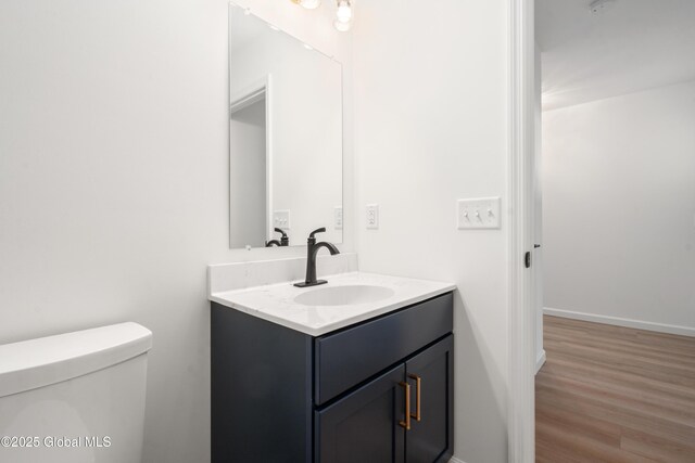 bathroom featuring hardwood / wood-style flooring, vanity, and toilet